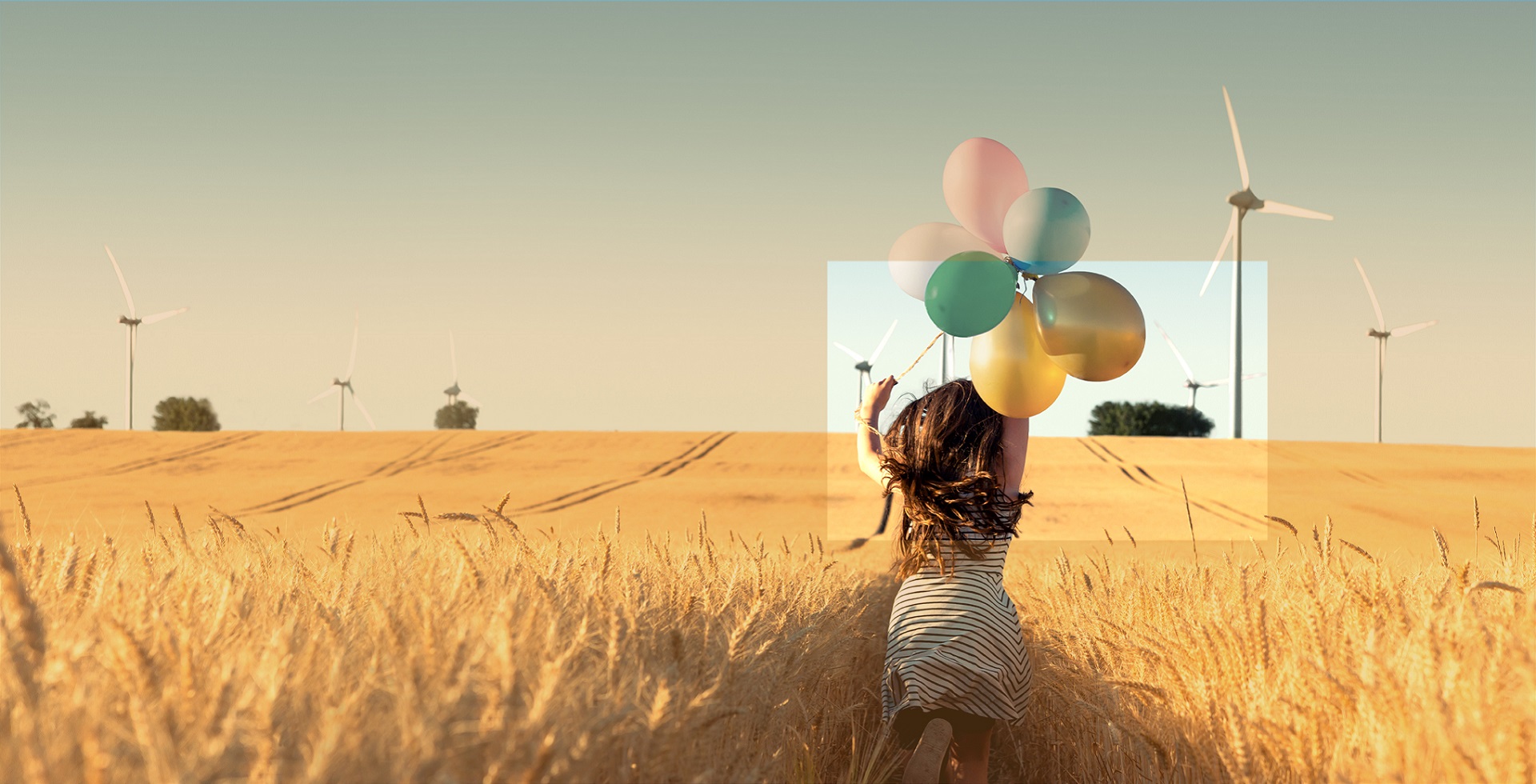 Girl with balloons running through windmill field